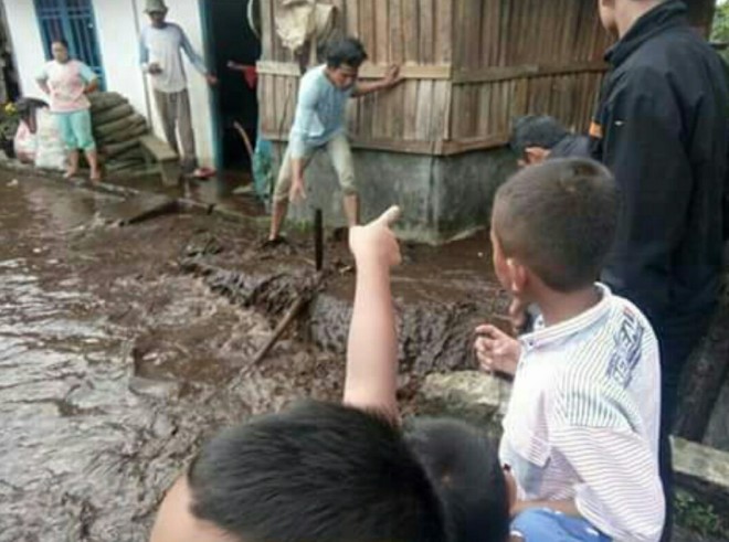 Warga saat membersihkan sampah dan lumpur yang menumpuk.